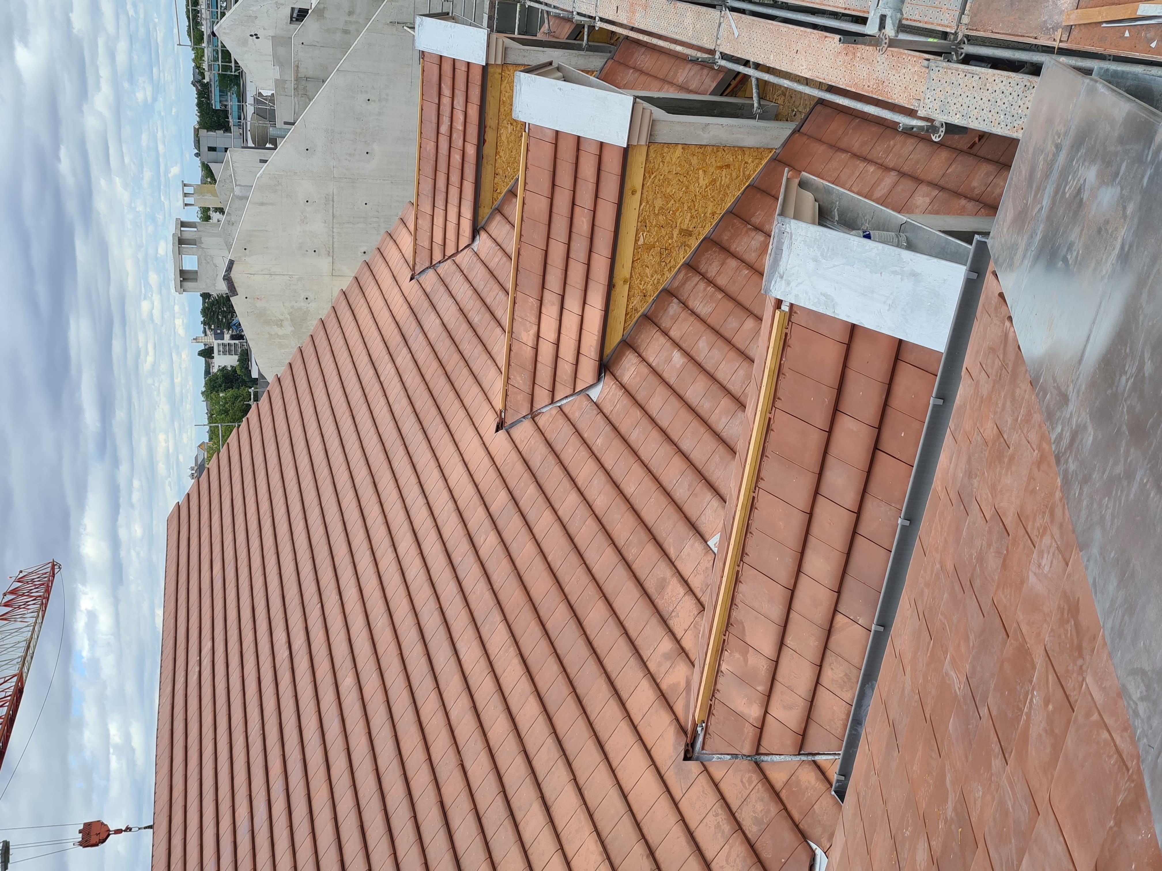 Toiture complexe en tuiles avec multiples pans et cheminee en Ile-de-France